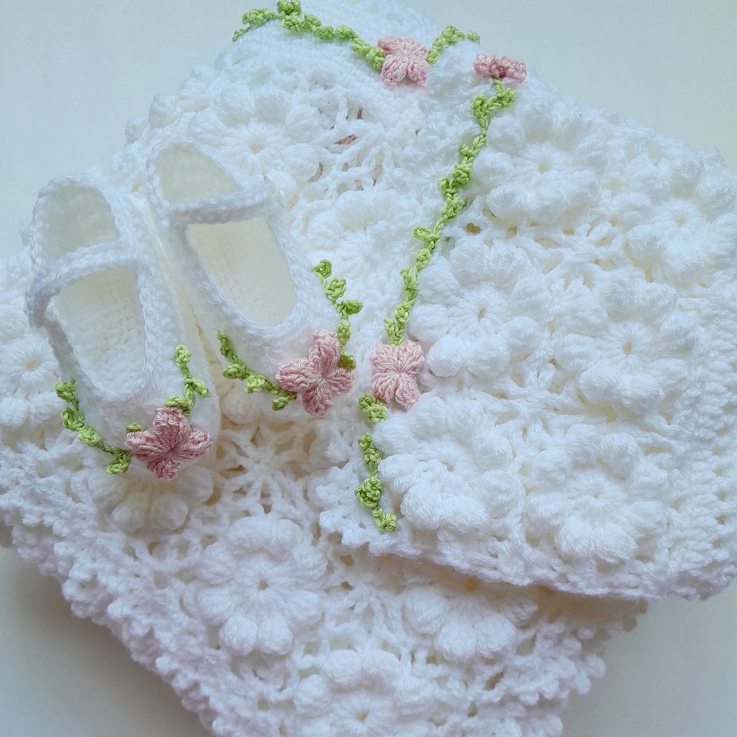 White lace fabric with pink floral embellishments on a light background