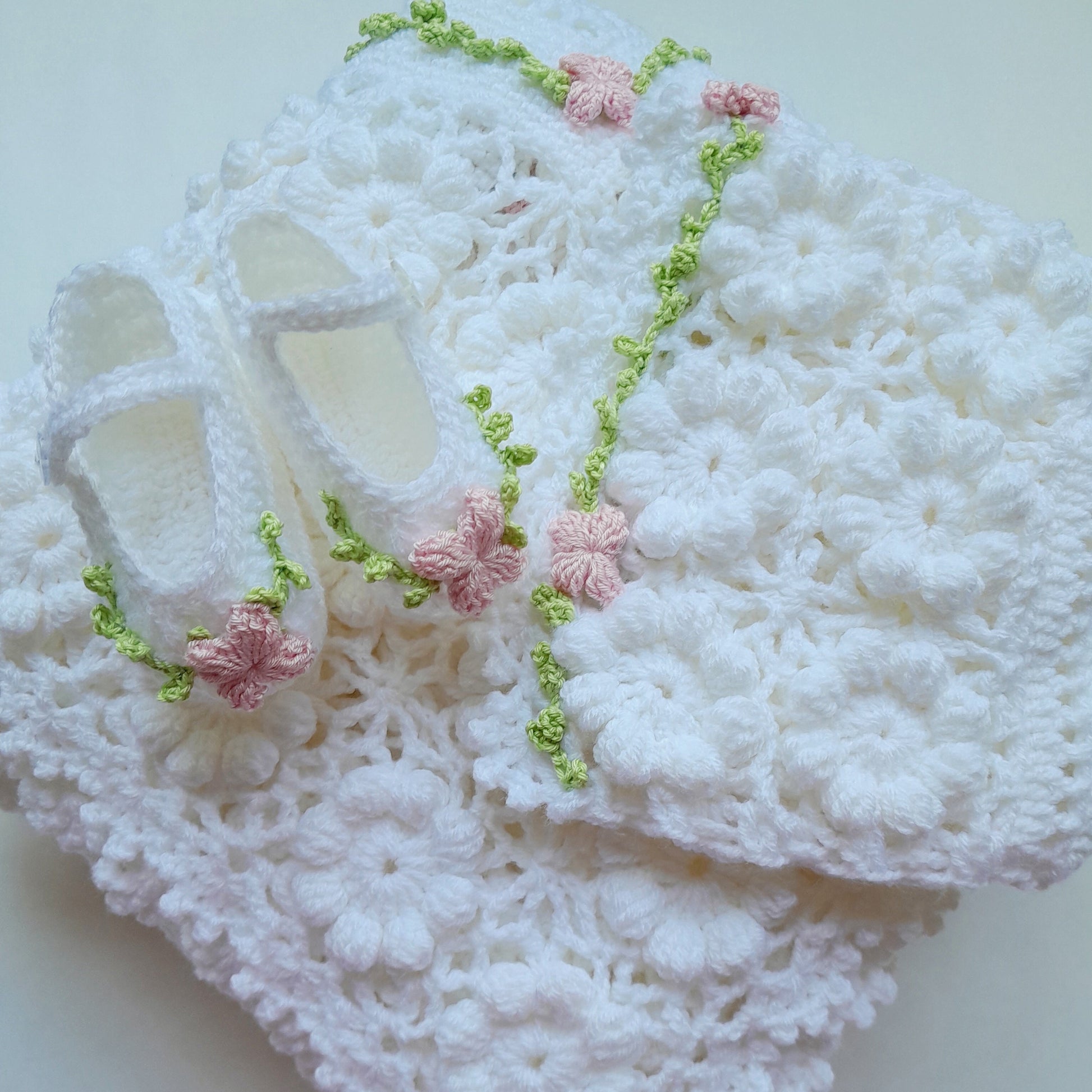 White lace fabric with pink floral embellishments on a light background